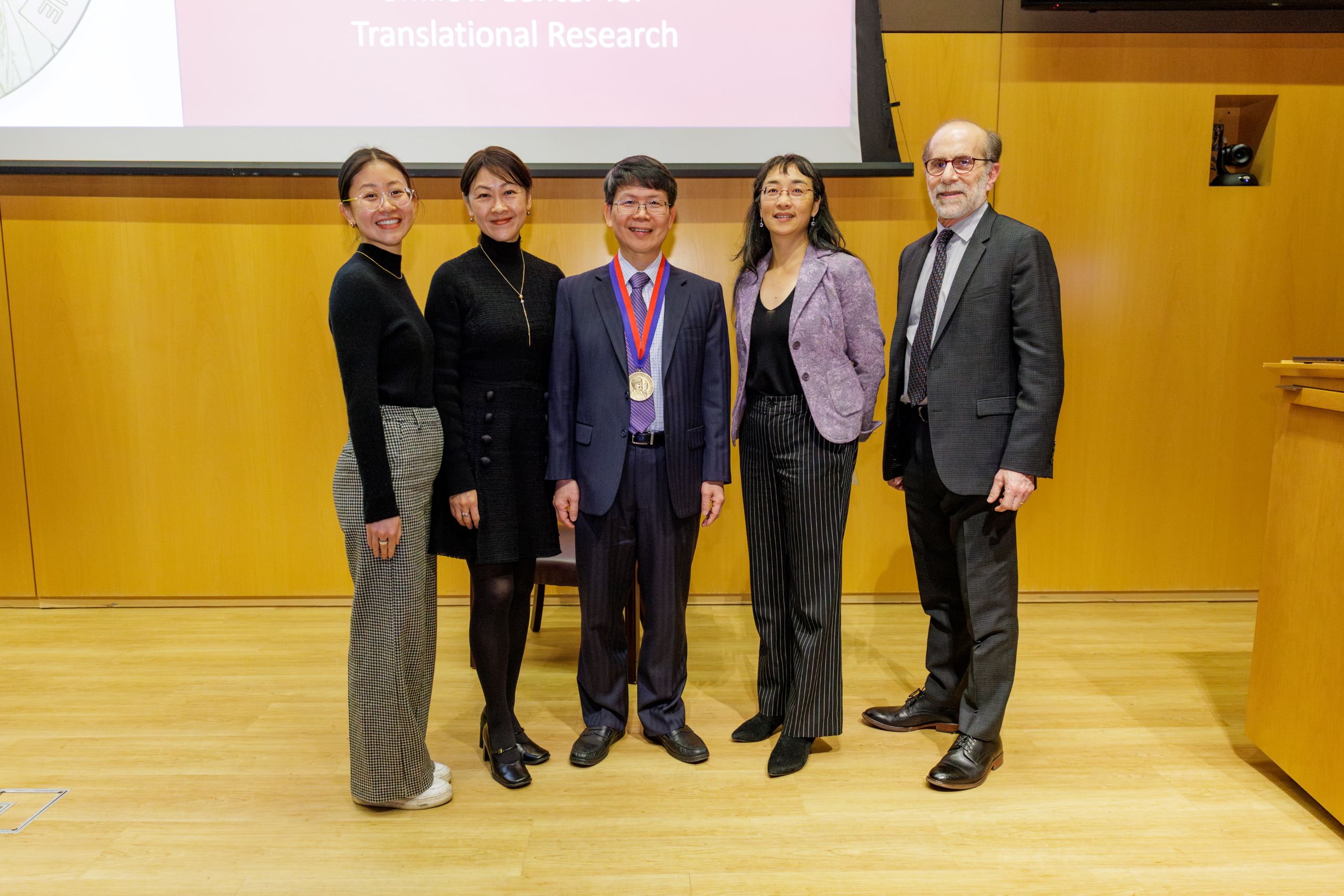 Dr. Chen photographed with family and IRM leadership.
