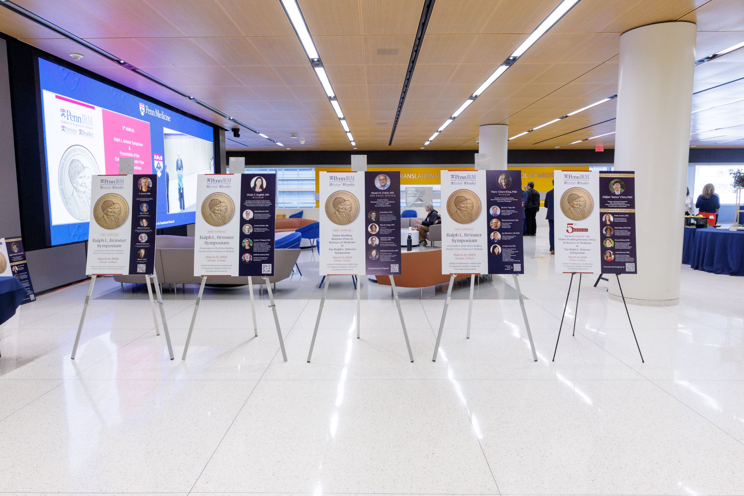 Photo showing posters from all 5 of the Brinster Symposiums.